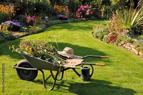 Foto: Schubkarre und Gießkanne im herbstlichen Garten Schubkarre und Gießkanne im herbstlichen Garten