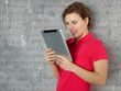 Woman leaning on a wall surfing on the internet with touchpad