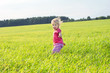 The little girl runs across the field on a decline