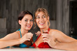 Two female friends drinking tea in swimming pool