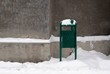trash can covered with snow while snowing