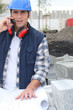 Building foreman with a phone and plans