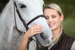 Blond woman petting horse