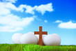 white eggs and wood cross on grass with blue sky