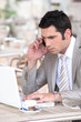 Businessman on phone working on laptop