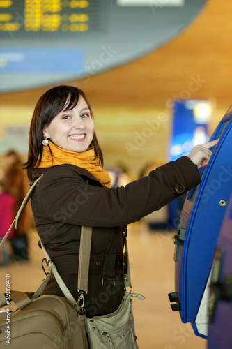 Photo: Girl doing self-checkin in the airport Girl doing self-checkin in the airport