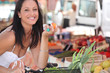 Brunette buying fruit and vegetables at local market