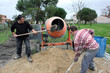 Labourers using a cement fixer