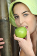 Woman wearing hat and eating green apple