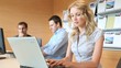 Blond office worker in office with workteam