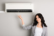 Photo: young woman showing air conditioner young woman showing air conditioner