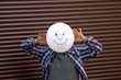 Man hält Ballon vor Gesicht. Freches Ballongesicht