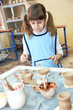 child girl shaping clay in pottery studio