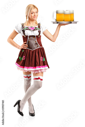 Foto: Woman wearing traditional costume and holding three beer glasses Woman wearing traditional costume and holding three beer glasses