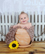 adorable baby boy sitting in clay flower pot