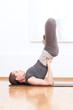 Woman doing stretching yoga exercise at sport gym