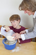 Junge macht Faxen beim Backen mit seiner Mutter