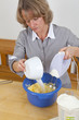 beim Backen - Hausfrau rührt Teig an