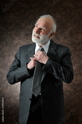 Photo: a man fixes his tie a man fixes his tie