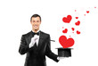 Smiling magician and a red heart shaped objects coming out of a