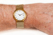Photo: Gold watch with white face on hairy wrist Gold watch with white face on hairy wrist