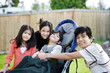 Three children surrounding a small disabled child in wheelchair