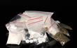 Cocaine and marihuana in packages on black background