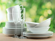 Clean dishes on wooden table on green background Clean dishes on wooden table on green background
