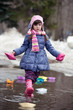 Cute girl playing with paper boats