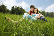 Couple spending time on grass lying on the meadow
