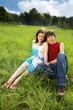 Couple spending time on grass lying on the meadow
