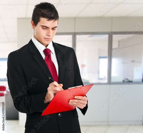 Photo: Businessman writing a document Businessman writing a document
