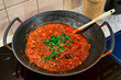 Bolognese sauce cooking in a wok on an induction cooker
