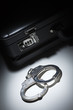 Photo: Pair of Handcuffs and Briefcase Under Spot Light Pair of Handcuffs and Briefcase Under Spot Light
