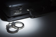 Photo: Pair of Handcuffs and Briefcase Under Spot Light Pair of Handcuffs and Briefcase Under Spot Light