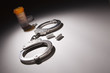 Foto: Handcuffs, Medicine Bottle and Pills Under Spot Light Handcuffs, Medicine Bottle and Pills Under Spot Light