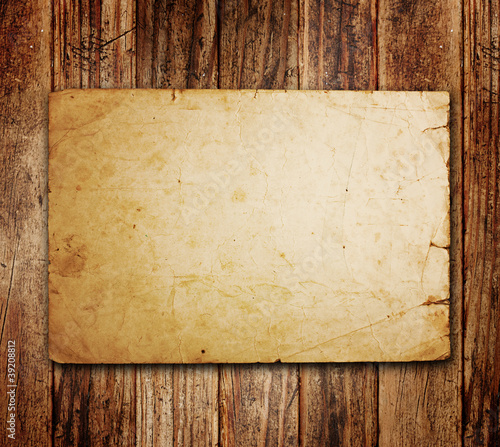 Photo: Old paper on the wood background Old paper on the wood background