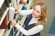 young adult student selecting book in library