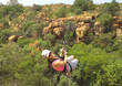 Lady sliding on a zip line across a gorge