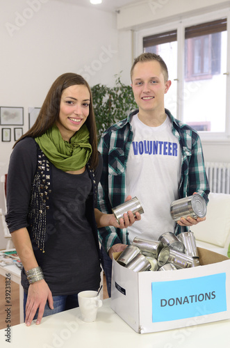 Photo: young volunteer couple with food donation box young volunteer couple with food donation box