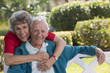 Portrait of a senior woman hugging her husband from behind