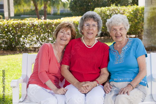 Photo: Portrait of three friends smiling in a park Portrait of three friends smiling in a park