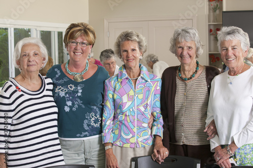 Photo: Portrait of senior female friends smiling at a lunch Portrait of senior female friends smiling at a lunch