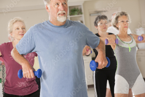 Photo: Seniors exercising with dumbbells in a health club Seniors exercising with dumbbells in a health club