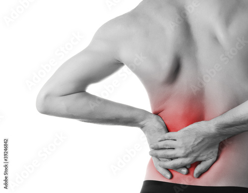 Photo: Rear view of a young man holding his back in pain, isolated on w Rear view of a young man holding his back in pain, isolated on w