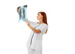 Pretty caucasian female doctor looking at x-ray