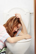 Teen woman vomiting in toilet