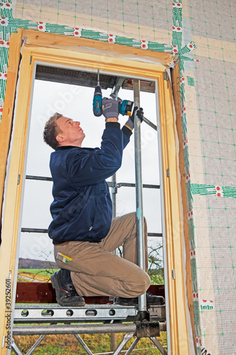 Photo: carpenter mounting a new window carpenter mounting a new window