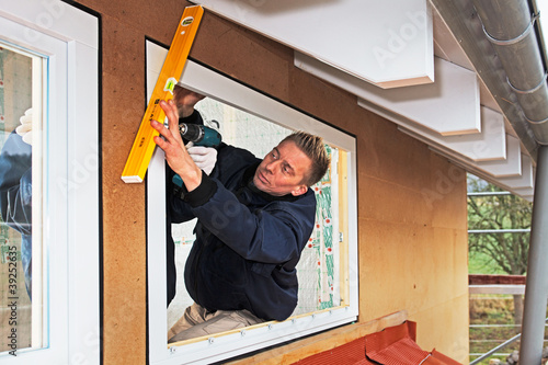 Photo: carpenter mounting a new window carpenter mounting a new window
