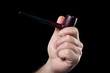 Foto: smoking pipe in hand isolated on black background smoking pipe in hand isolated on black background